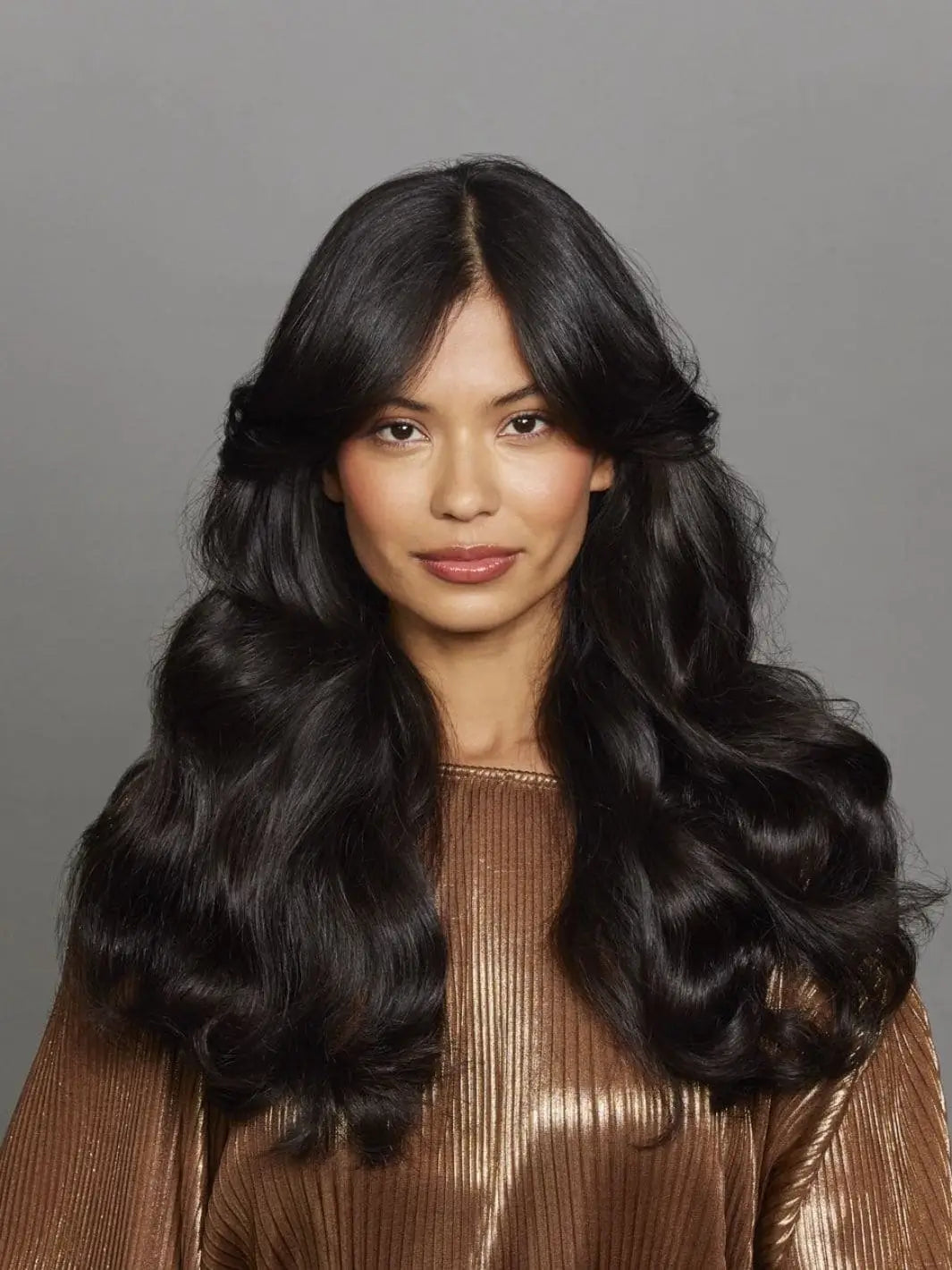 A model with voluminous, glossy brunette waves styled using Hair by Sam McKnight Modern Hairspray | Twentyseven Toronto