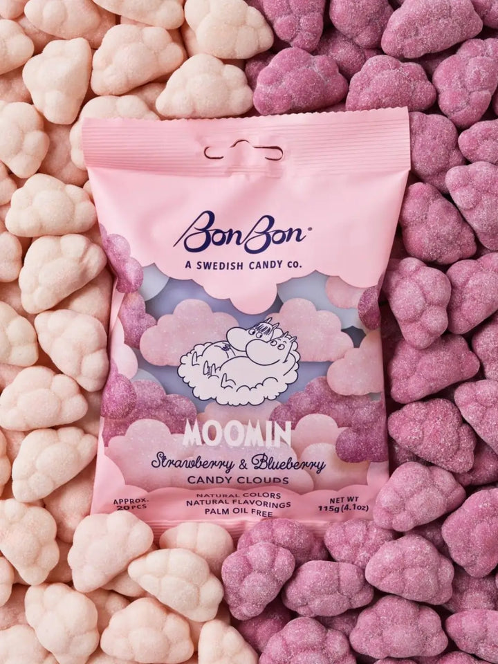 A pink bag of BonBon Swedish Candy Moomin Candy Clouds sits nestled on top of a dense background of pink and purple cloud-shaped gummy candies | Twentyseven Toronto