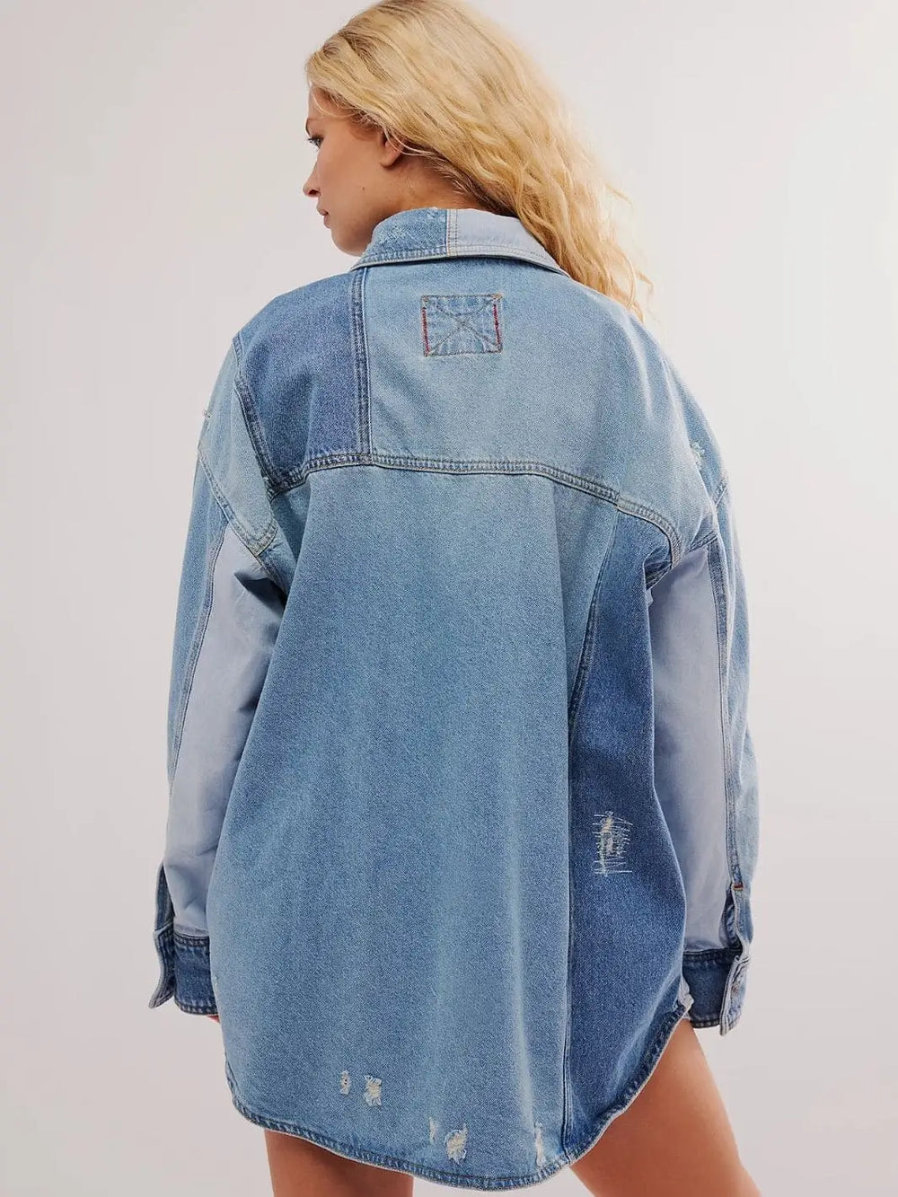 A view from behind shows the multi-toned denim panels and distressed detailing on the back of the Free People We The Free Mountain Roads Shirt - Mixed | Twentyseven Toronto