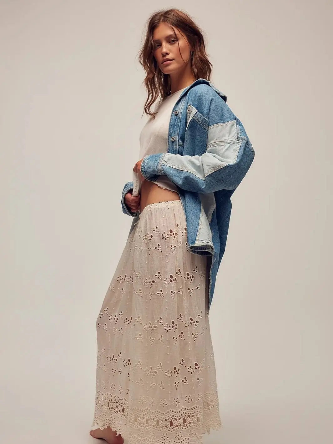 A model poses from the side wearing the button-down Free People We The Free Mountain Roads Shirt - Mixed paired with a white top and a long, eyelet lace skirt | Twentyseven Toronto