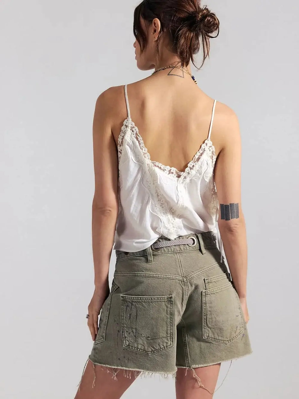 A rear view highlights the raw, frayed hems, large patch pockets, and subtle paint-splatter detailing on the back of the Free People Moxie Barrel Shorts in Fern | Twentyseven Toronto