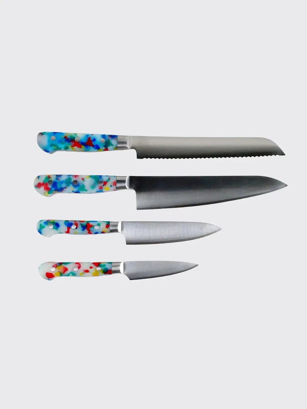 The Fredericks and Mae Multi/Confetti Paring Knife is shown at the bottom of a vertical stack of four kitchen knives, each featuring a vibrant, multicolored speckled handle against a light gray background | Twentyseven Toronto