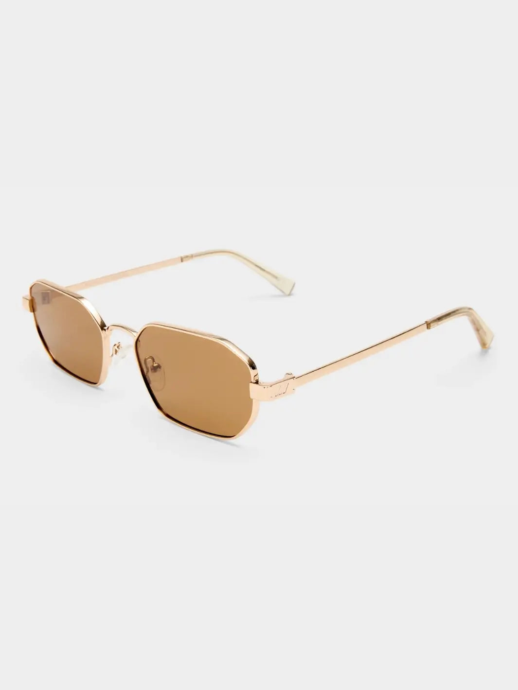 A three-quarter studio product shot of the Le Specs Mythic - Gold Light Brown Mono sunglasses showcasing their angular gold frame, light brown lenses, and clear temple tips | Twentyseven Toronto