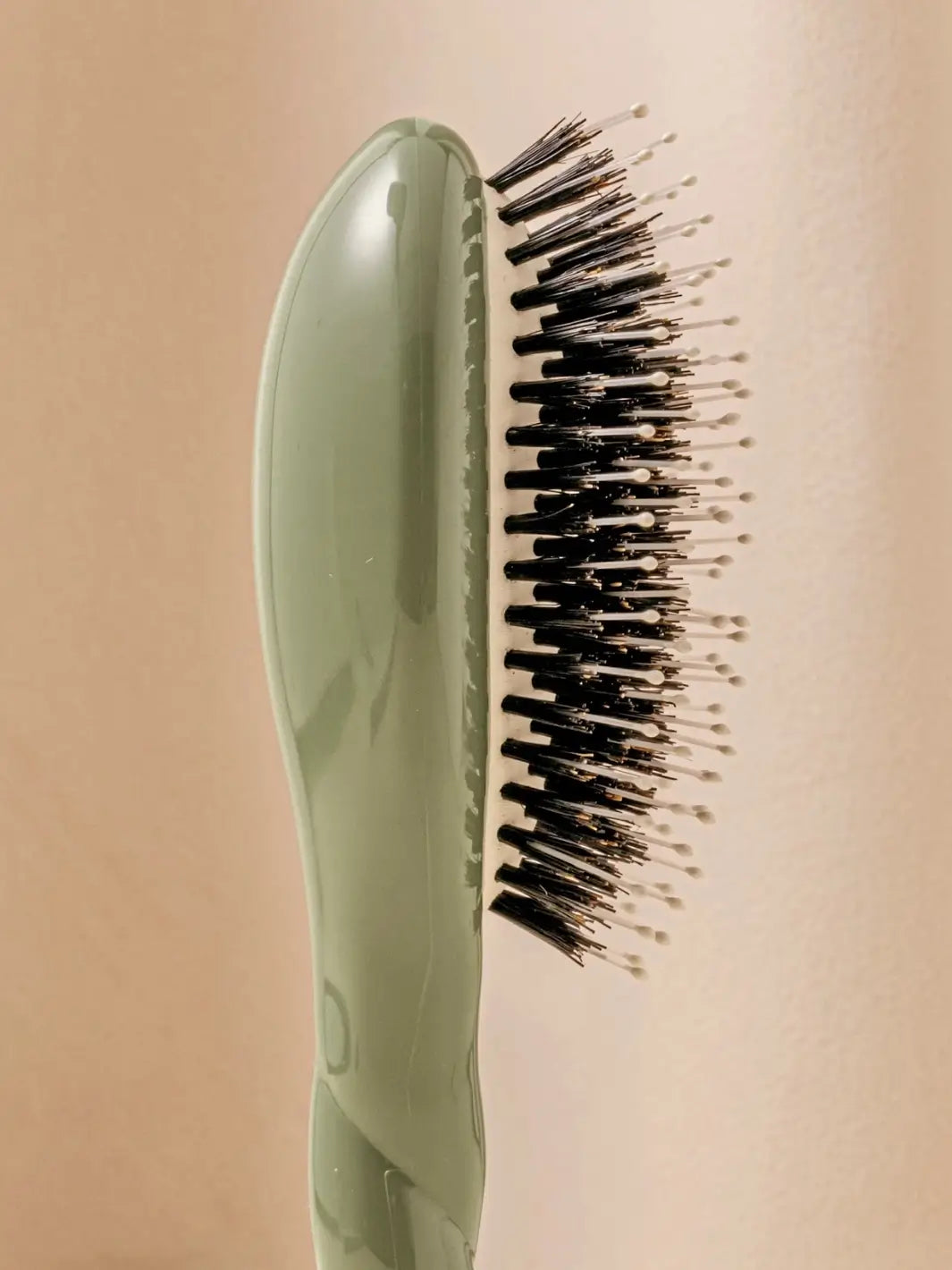 Close-up side view shot highlights the tiered bristle design of La Bonne Brosse N.03 Small The Essential Softness & Sensitive Scalp Brush in Almond Green | Twentyseven Toronto