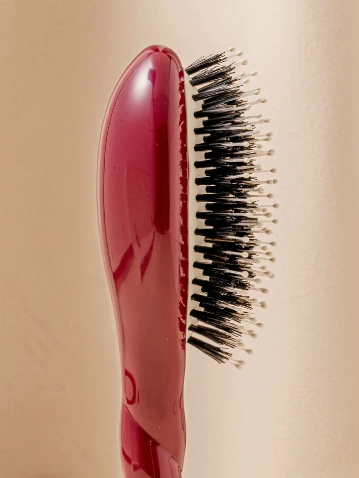Close-up side view shot highlights the tiered bristle design of La Bonne Brosse N.03 Small The Essential Softness & Sensitive Scalp Brush in Cherry Red | Twentyseven Toronto