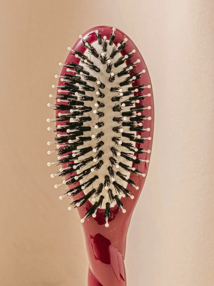 Front shot of the oval head and high-quality tufts of La Bonne Brosse N.03 Small The Essential Softness & Sensitive Scalp Brush in Cherry Red | Twentyseven Toronto