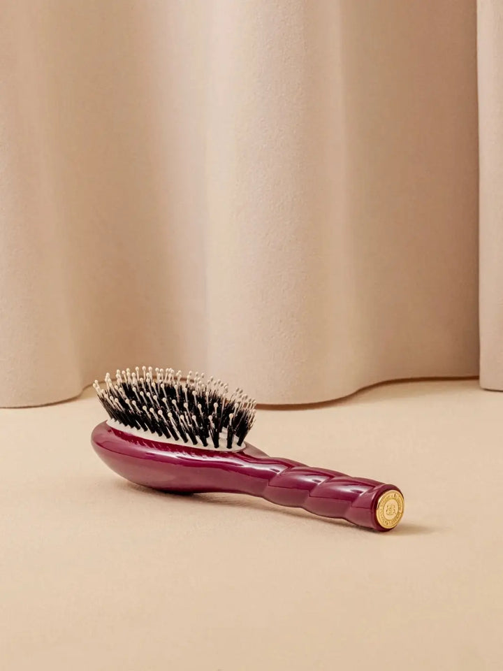 La Bonne Brosse N.03 Small The Essential Softness & Sensitive Scalp Brush in Cherry Red resting on a neutral surface against a soft draped curtain background | Twentyseven Toronto
