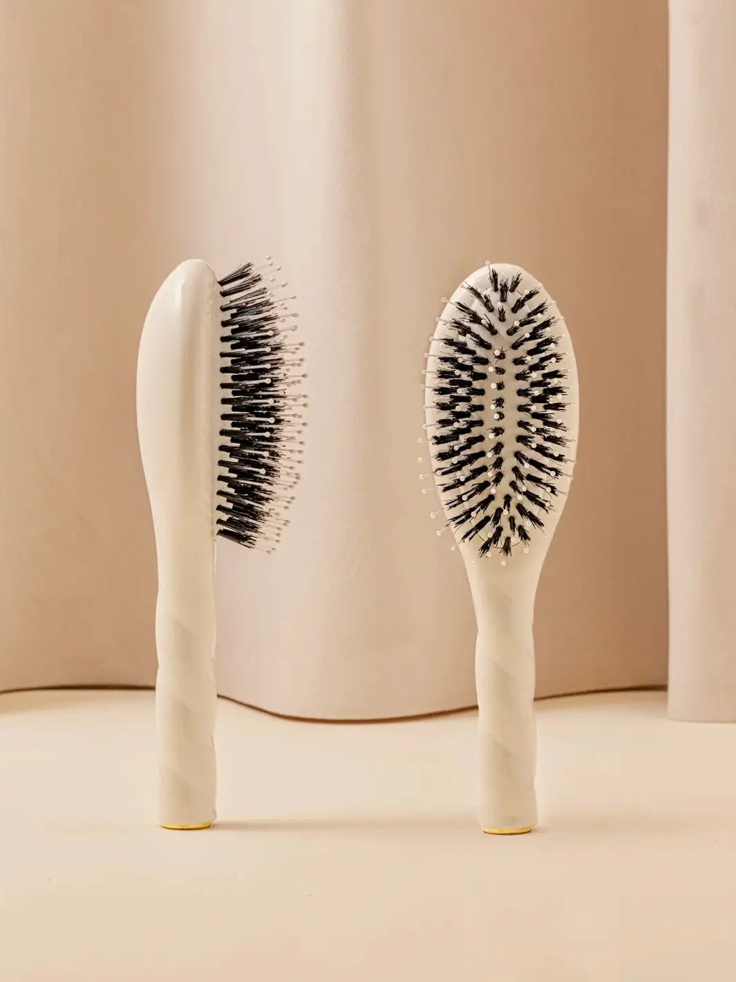 Front and side view of La Bonne Brosse N.03 Small The Essential Softness & Sensitive Scalp Brush in Creamy White featuring a twisted ergonomic handle and natural boar and nylon bristles | Twentyseven Toronto