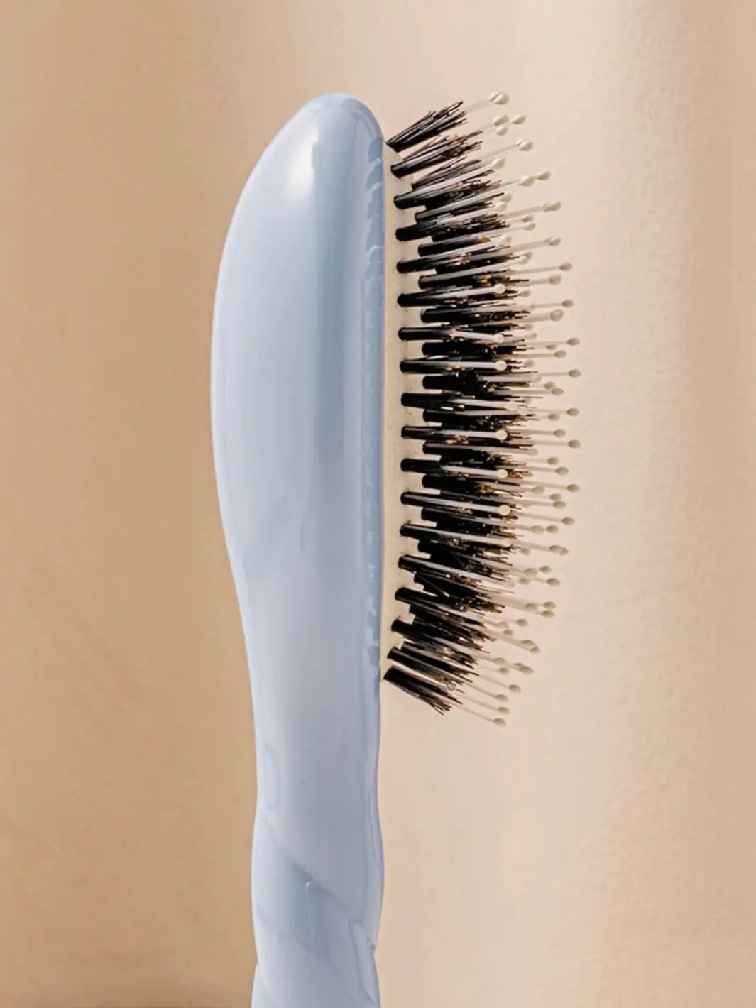 Close-up side view shot highlights the tiered bristle design of La Bonne Brosse N.03 Small The Essential Softness & Sensitive Scalp Brush in Light Blue | Twentyseven Toronto
