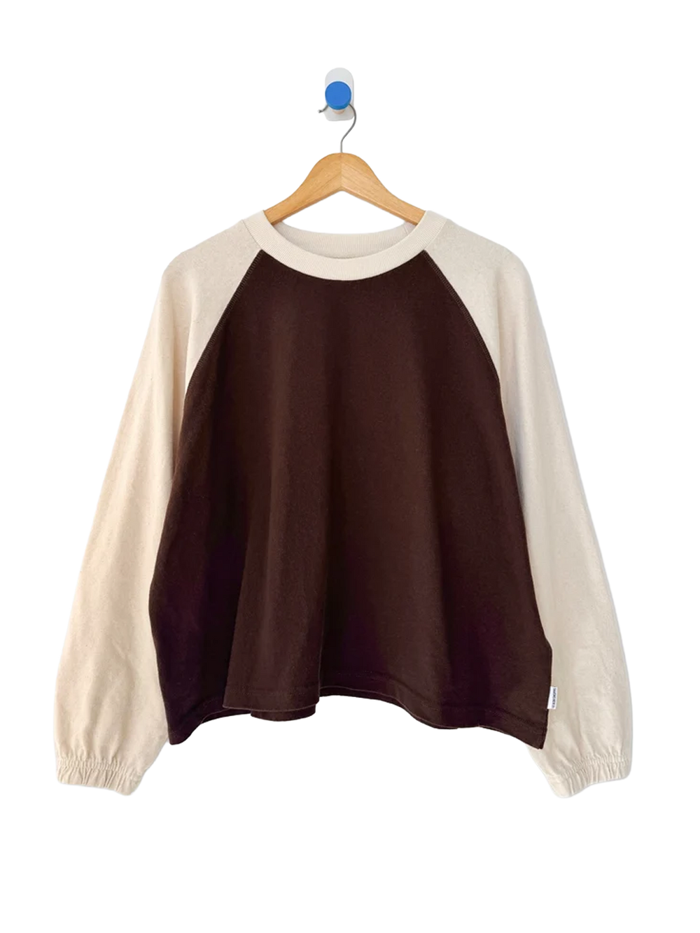 Heavy Naturelle Tee in Chestnut/Naturel displayed on a wooden hanger, featuring a chocolate brown body, contrasting cream raglan sleeves, ribbed crew neckline and elasticated cuffs | Twentyseven Toronto
