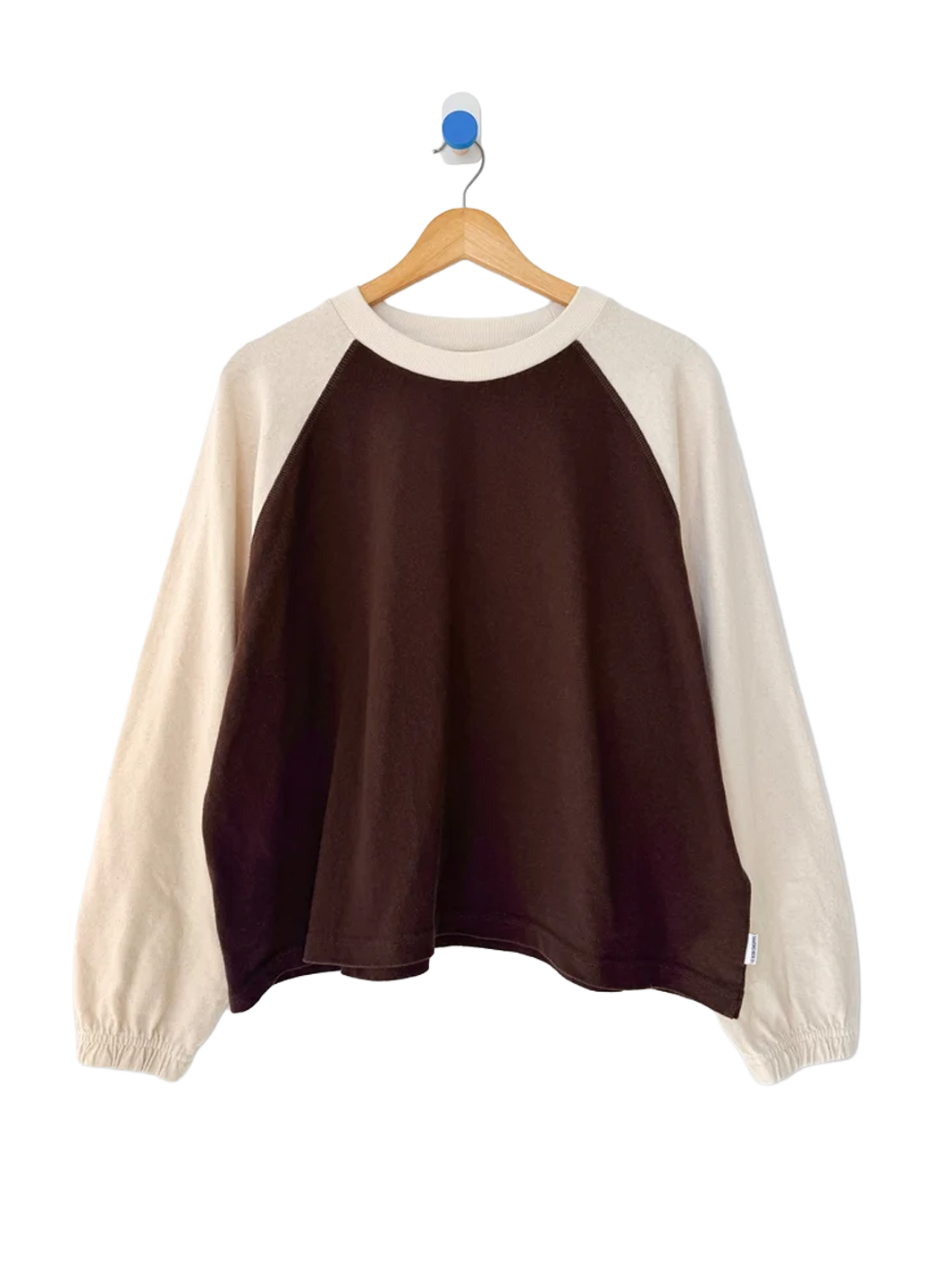 Heavy Naturelle Tee in Chestnut/Naturel displayed on a wooden hanger, featuring a chocolate brown body, contrasting cream raglan sleeves, ribbed crew neckline and elasticated cuffs | Twentyseven Toronto
