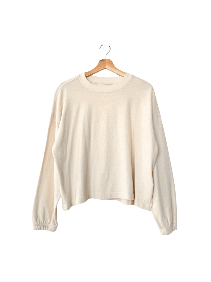 Cream 'Naturelle Tee' sweater in 'Naturel' from Le Bon Shoppe on a wooden hanger | Twentyseven Toronto