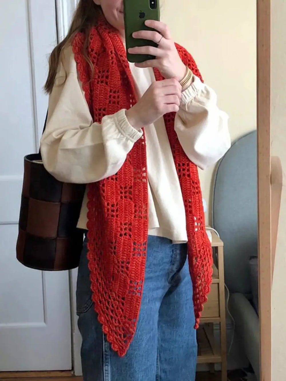 Person wearing a red knitted scarf, cream 'Naturelle Tee' sweater in 'Naturel' from Le Bon Shoppe, and blue jeans taking a mirror selfie | Twentyseven Toronto