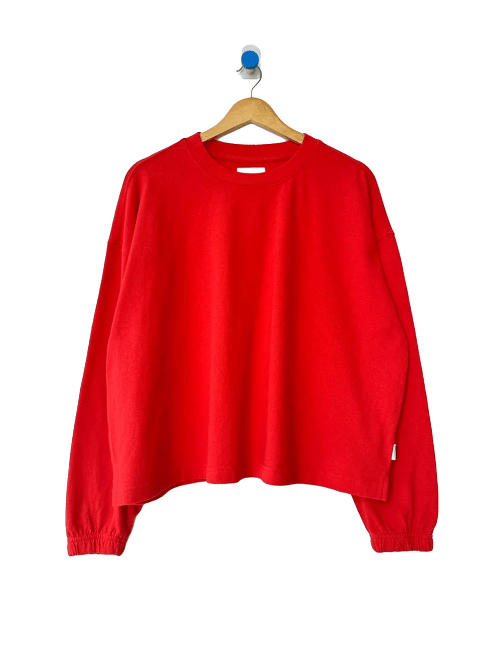Le Bon Shoppe Naturelle Tee in Tomato on a wooden hanger against a white background | Twentyseven Toronto