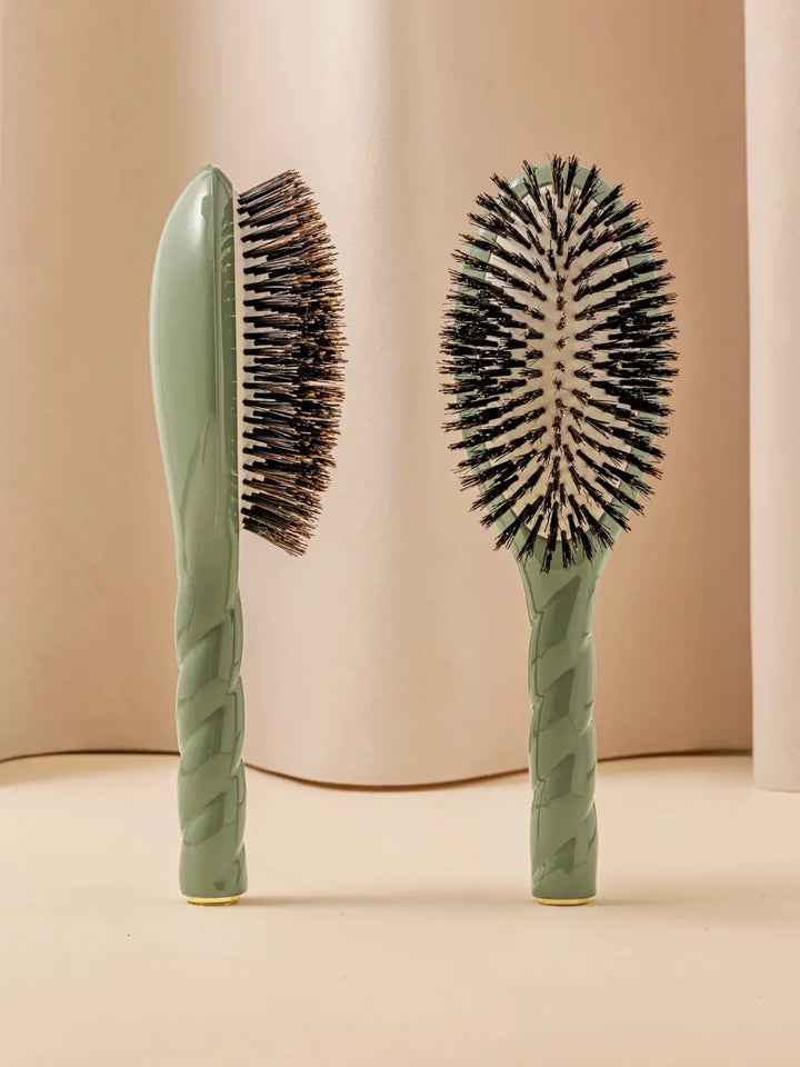 Front and side view of La Bonne Brosse N.01 The Shine & Care Hairbrush The Universal Brush in Almond Green featuring a twisted ergonomic handle and natural boar bristles | Twentyseven Toronto