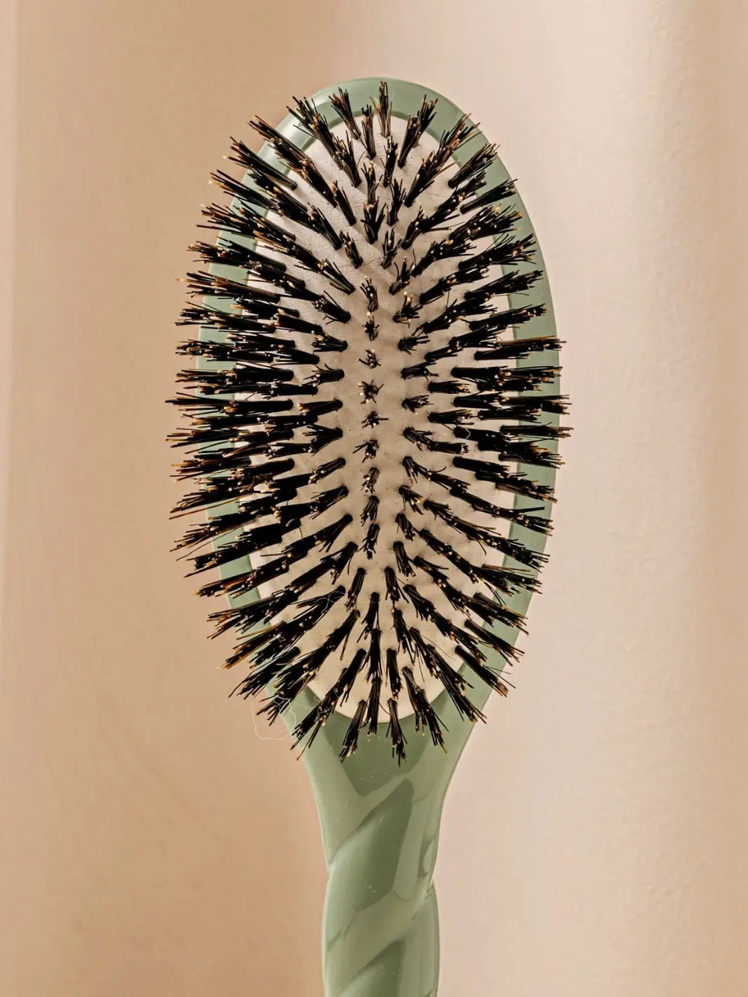 Front shot of the oval head and high-quality tufts of La Bonne Brosse N.01 The Shine & Care Hairbrush The Universal Brush in Almond Green | Twentyseven Toronto