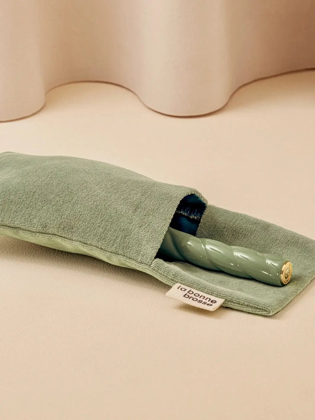 La Bonne Brosse N.01 The Shine & Care Hairbrush The Universal Brush in Orange Coral is partially tucked into a luxurious matching green velvet travel pouch | Twentyseven Toronto