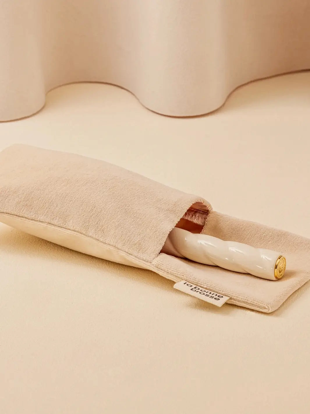 La Bonne Brosse N.01 The Shine & Care Hairbrush The Universal Brush in Orange Coral is partially tucked into a luxurious matching white velvet travel pouch | Twentyseven Toronto