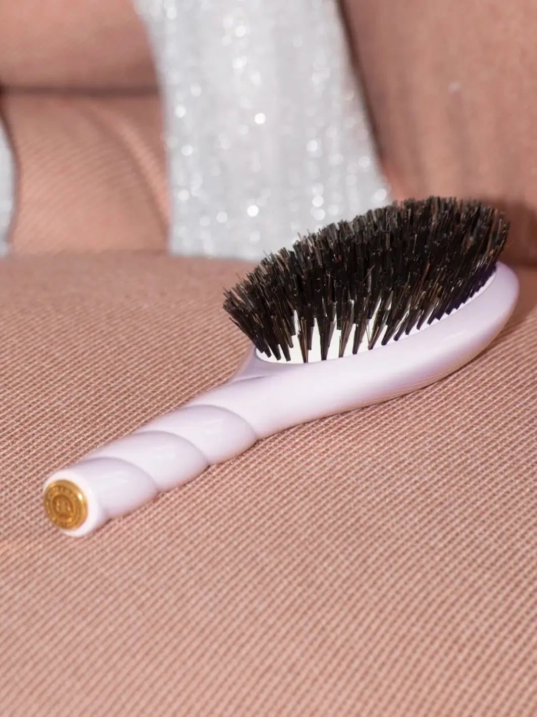 Side view of the La Bonne Brosse N.01 Large The Shine & Care Hairbrush The Universal Brush in Lilac Pink resting on a blush fabric | Twentyseven Toronto