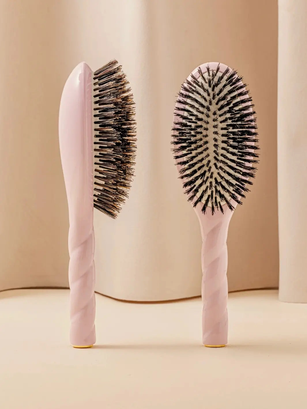 Front and side view of La Bonne Brosse N.01 The Shine & Care Hairbrush The Universal Brush in Lilac Pink featuring a twisted ergonomic handle and natural boar bristles | Twentyseven Toronto