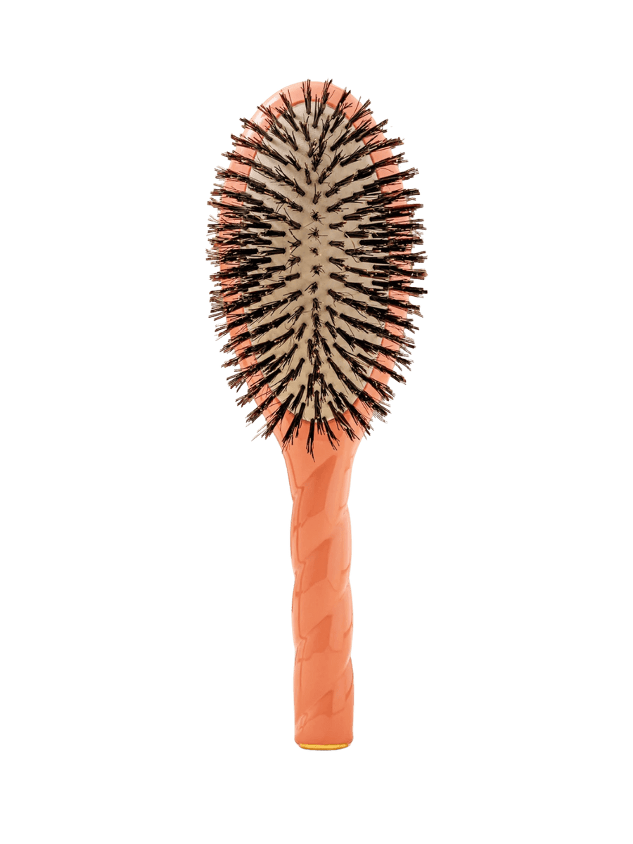 Front view of La Bonne Brosse N.01 The Shine & Care Hairbrush The Universal Brush in Orange Coral featuring a twisted ergonomic handle and natural boar bristles | Twentyseven Toronto