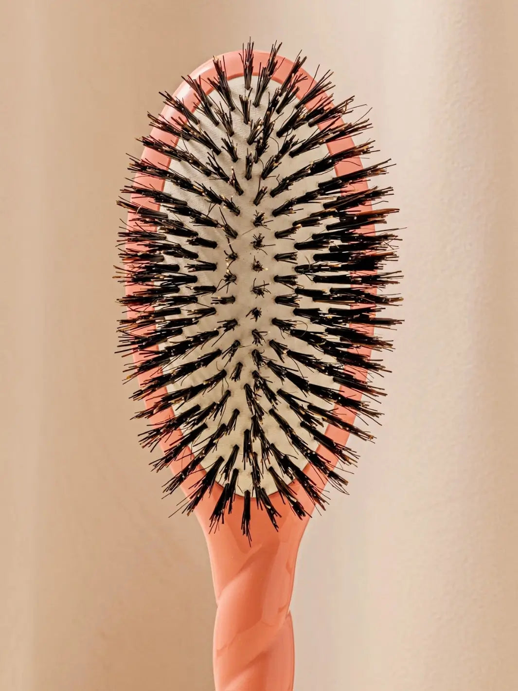 Front shot of the oval head and high-quality tufts of La Bonne Brosse N.01 The Shine & Care Hairbrush The Universal Brush in Orange Coral | Twentyseven Toronto
