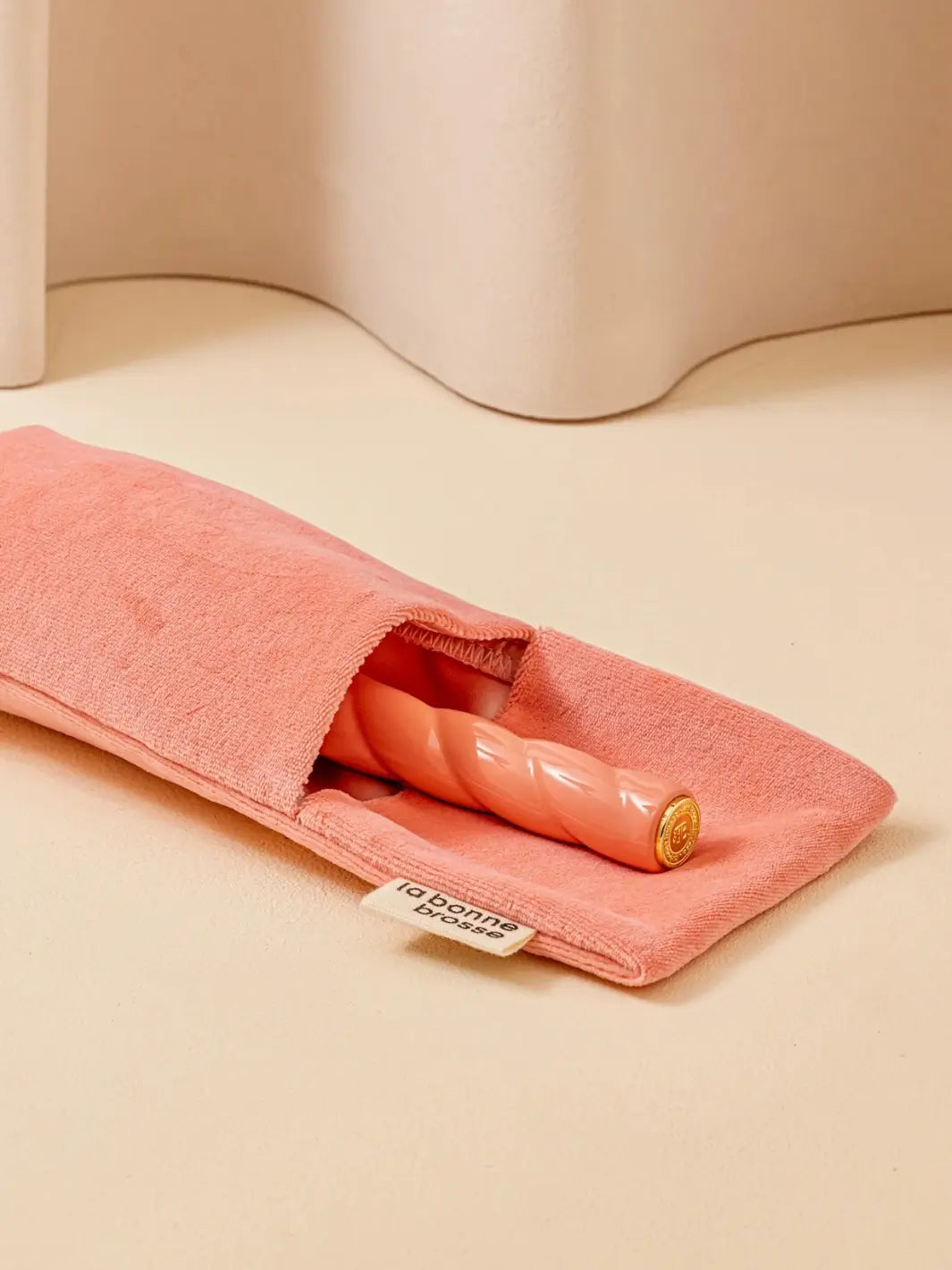 La Bonne Brosse N.01 The Shine & Care Hairbrush The Universal Brush in Orange Coral is partially tucked into a luxurious matching orange velvet travel pouch | Twentyseven Toronto