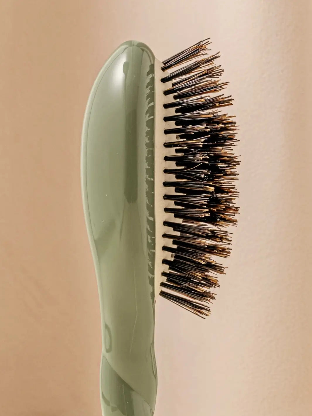 Close-up side view shot highlights the tiered bristle design of La Bonne Brosse N.01 Small The Shine & Care Hairbrush The Universal Brush in Almond Green | Twentyseven Toronto