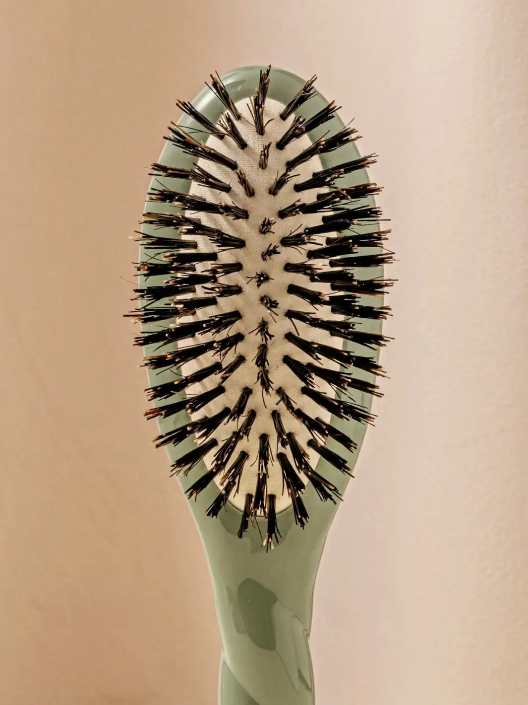 Front close up shot of the oval head and high-quality tufts of La Bonne Brosse N.01 Small The Shine & Care Hairbrush The Universal Brush in Almond Green | Twentyseven Toronto