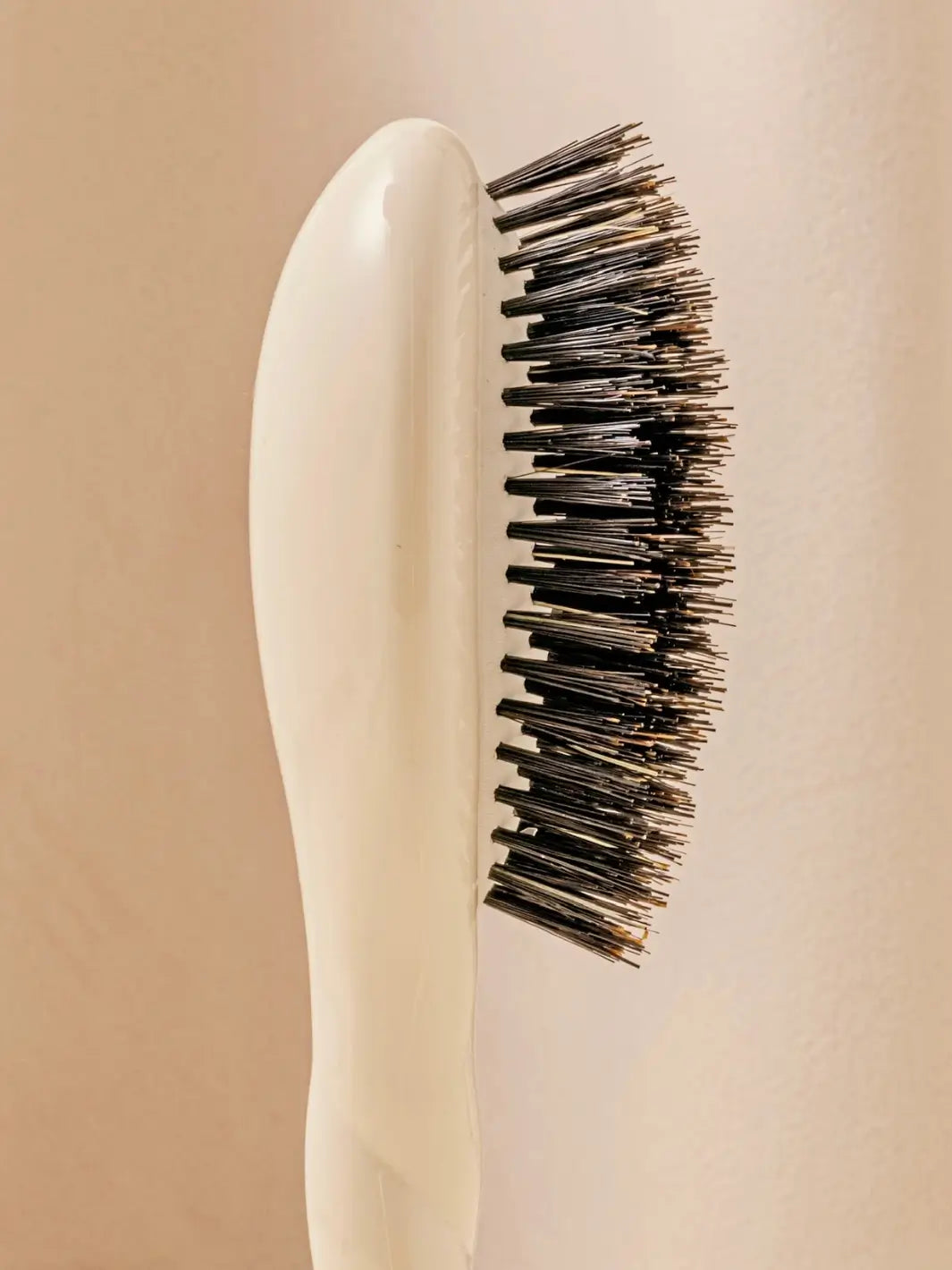 Close-up side view shot highlights the tiered bristle design of La Bonne Brosse N.01 Small The Shine & Care Hairbrush The Universal Brush in Creamy White | Twentyseven Toronto