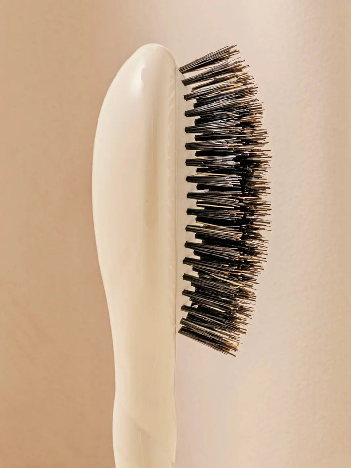 Close-up side view shot highlights the tiered bristle design of La Bonne Brosse N.01 Small The Shine & Care Hairbrush The Universal Brush in Creamy White | Twentyseven Toronto