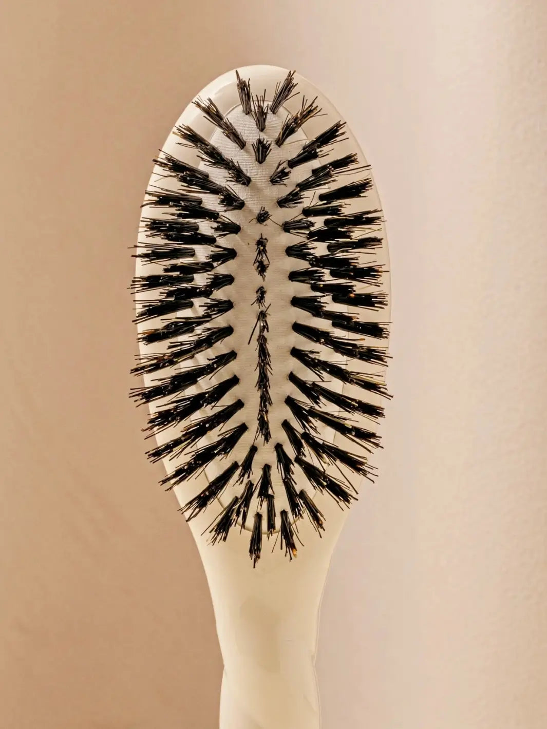 Front close up shot of the oval head and high-quality tufts of La Bonne Brosse N.01 Small The Shine & Care Hairbrush The Universal Brush in Creamy White | Twentyseven Toronto