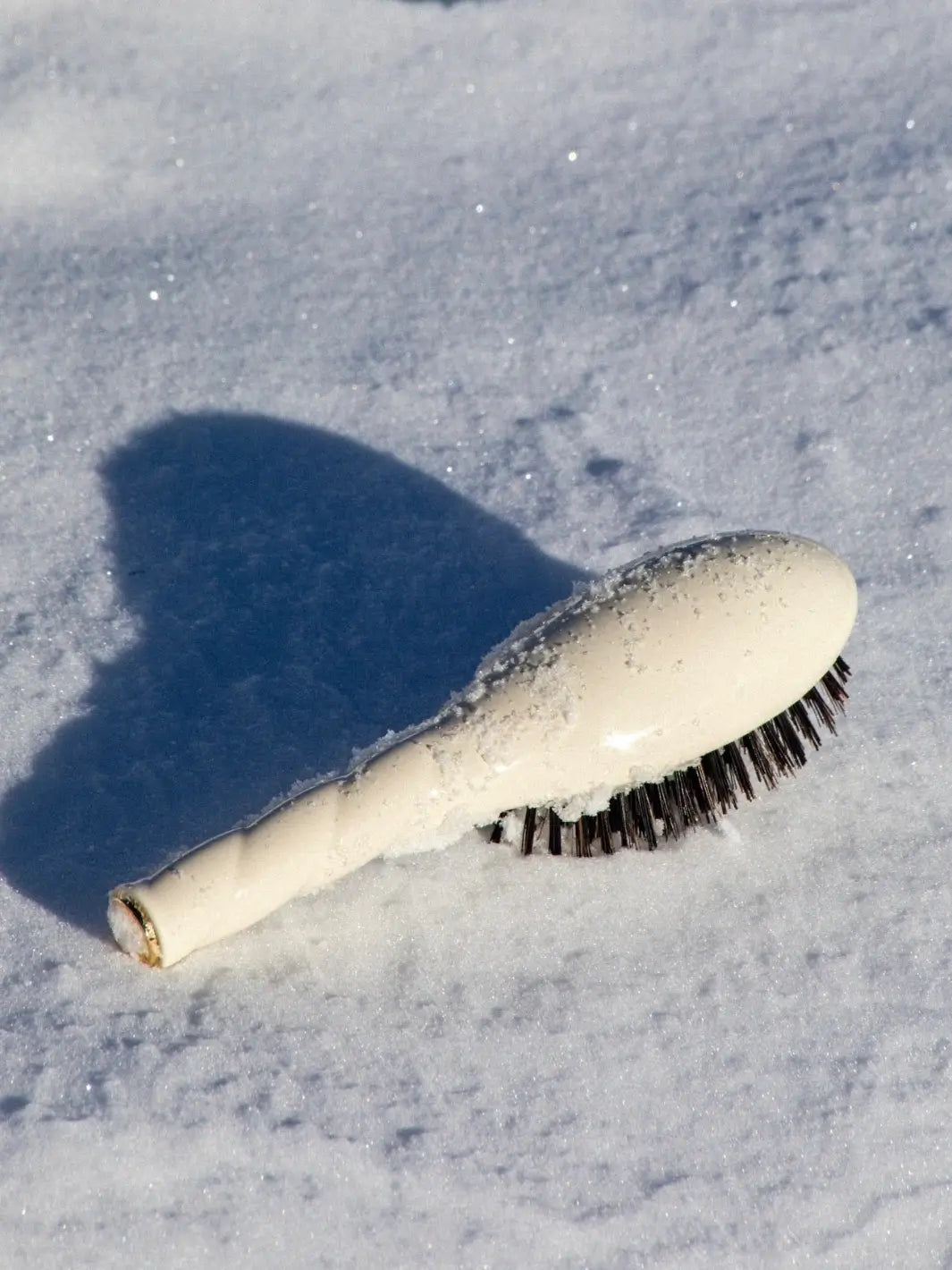 La Bonne Brosse N.01 Small The Shine & Care Hairbrush The Universal Brush in Creamy White lies nestled in fresh, powdery snow | Twentyseven Toronto