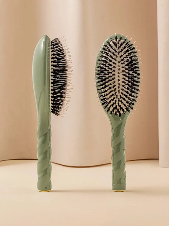 Front and side view of La Bonne Brosse N.02 Large The Essential Detangling & Conditioning Brush in Almond Green featuring a twisted ergonomic handle and natural boar bristles | Twentyseven Toronto
