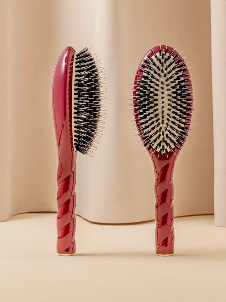 Front and side view of La Bonne Brosse N.02 Large The Essential Detangling & Conditioning Brush in Cherry Red featuring a twisted ergonomic handle and natural boar bristles | Twentyseven Toronto