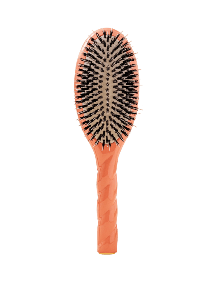 Front view of La Bonne Brosse N.02 Large The Essential Detangling & Conditioning Brush in Coral Orange featuring a twisted ergonomic handle and natural boar bristles | Twentyseven Toronto