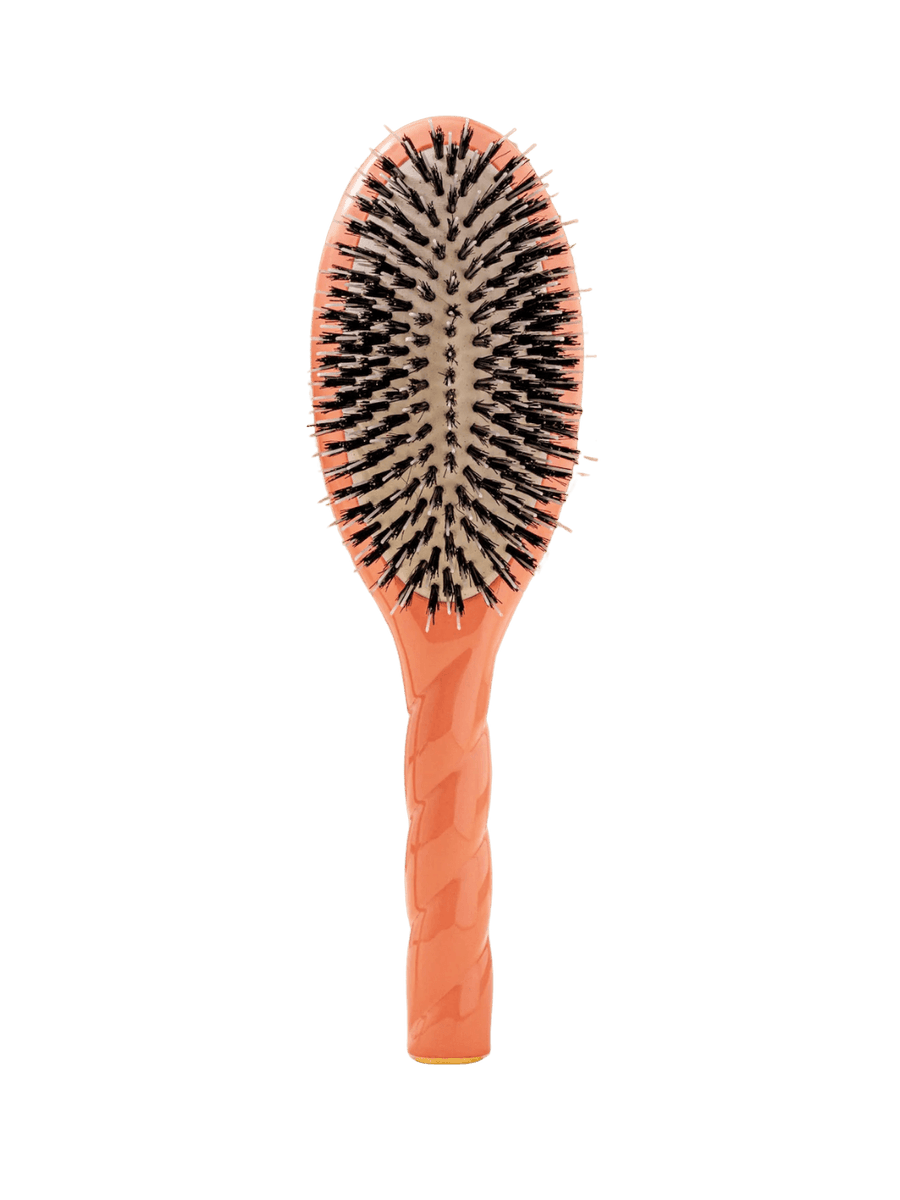 Front view of La Bonne Brosse N.02 Large The Essential Detangling & Conditioning Brush in Coral Orange featuring a twisted ergonomic handle and natural boar bristles | Twentyseven Toronto