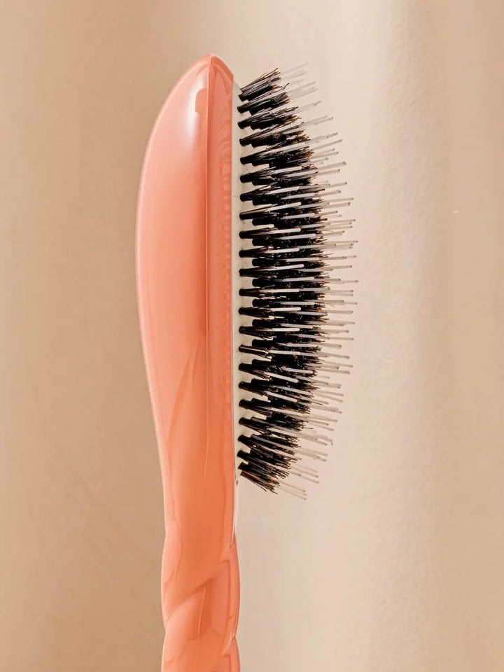 Close-up side profile shot highlights the tiered bristle design of La Bonne Brosse N.02 Large The Essential Detangling & Conditioning Brush in Orange Coral | Twentyseven Toronto