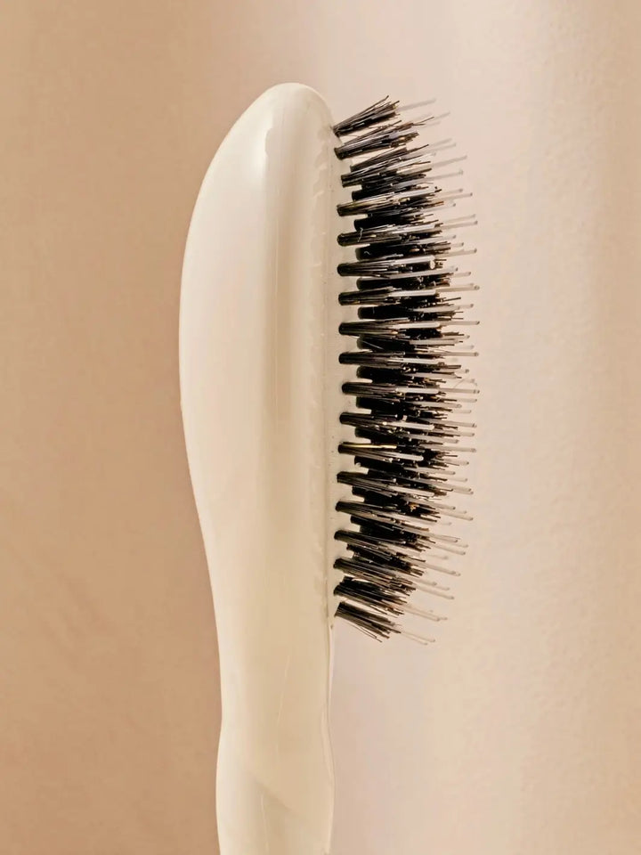 Close-up side profile shot highlights the tiered bristle design of La Bonne Brosse N.02 Small The Essential Detangling & Conditioning Brush in Creamy White | Twentyseven Toronto