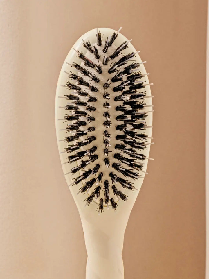 Front shot of the oval head and high-quality tufts of La Bonne Brosse N.02 Small The Essential Detangling & Conditioning Brush in Creamy White | Twentyseven Toronto