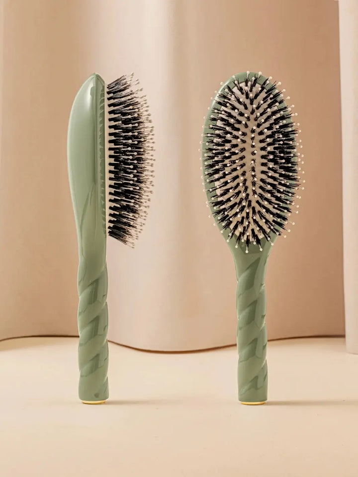 Front and side view of La Bonne Brosse N.03 Large The Essential Softness & Sensitive Scalp Brush in Almond Green featuring a twisted ergonomic handle and natural boar bristles | Twentyseven Toronto
