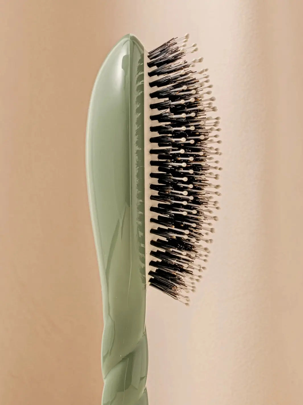 Close-up side image highlights the tiered bristle design of La Bonne Brosse N.03 Large The Essential Softness & Sensitive Scalp Brush in Almond Green | Twentyseven Toronto