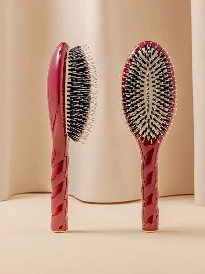Front and side view of La Bonne Brosse N.03 Large The Essential Softness & Sensitive Scalp Brush in Cherry Red featuring a twisted ergonomic handle and natural boar bristles | Twentyseven Toronto