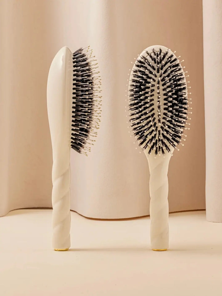 Front and side view of La Bonne Brosse N.03 Large The Essential Softness & Sensitive Scalp Brush in Creamy White featuring a twisted ergonomic handle and natural boar bristles | Twentyseven Toronto