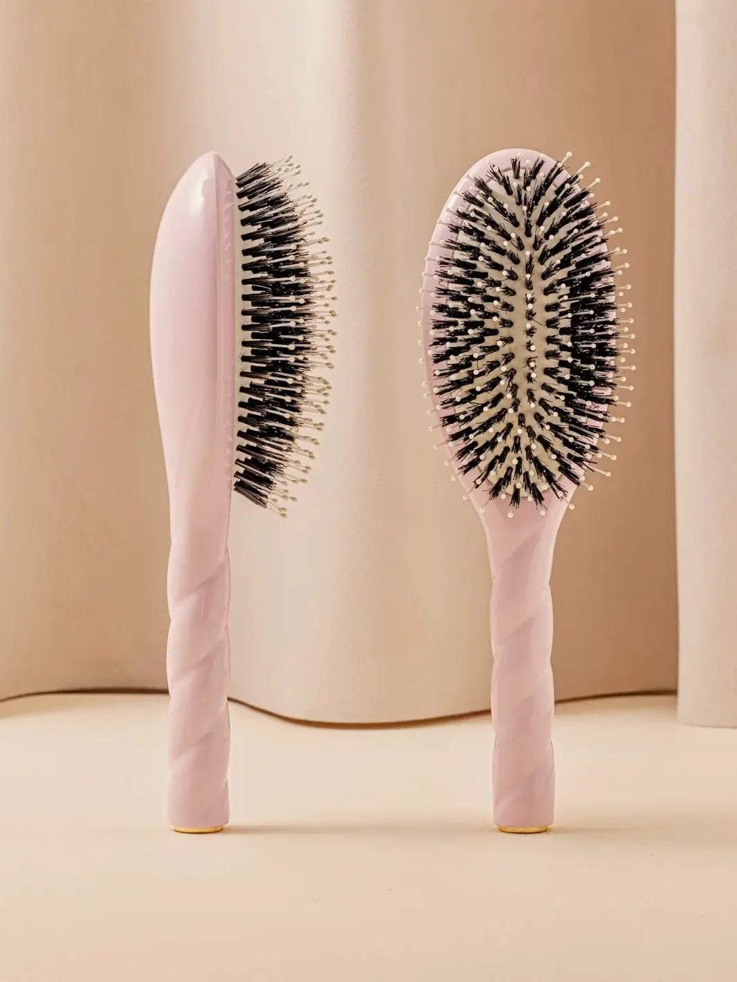Front and side view of La Bonne Brosse N.03 Large The Essential Softness & Sensitive Scalp Brush in Lilac Pink featuring a twisted ergonomic handle and natural boar bristles | Twentyseven Toronto