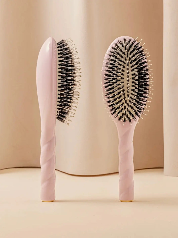 Front and side view of La Bonne Brosse N.03 Large The Essential Softness & Sensitive Scalp Brush in Lilac Pink featuring a twisted ergonomic handle and natural boar bristles | Twentyseven Toronto