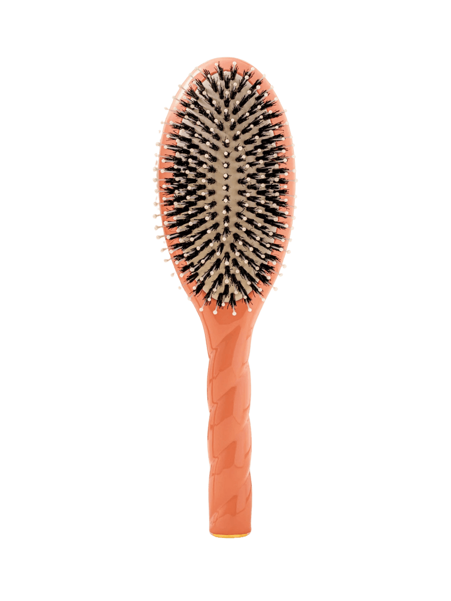 Front view of La Bonne Brosse N.03  Large The Essential Softness & Sensitive Scalp Brush in Orange Coral featuring a twisted ergonomic handle, boar bristle and nylon hairbrush | Twentyseven Toronto