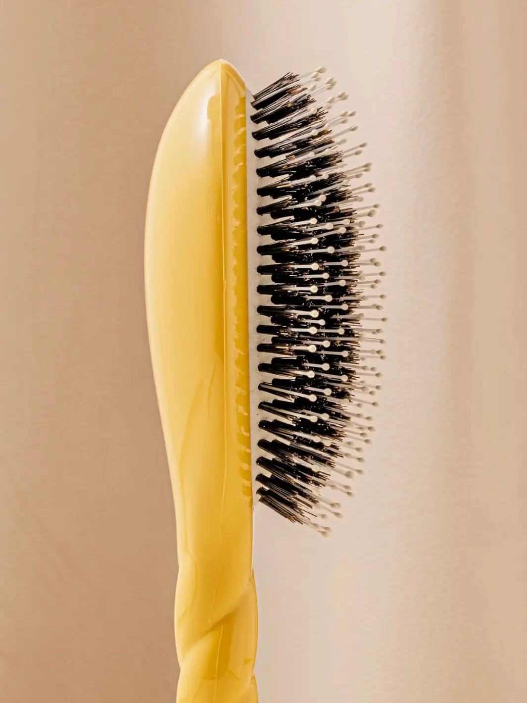 Close-up side image highlights the tiered bristle design of La Bonne Brosse N.03 Large The Essential Softness & Sensitive Scalp Brush in Saffron Yellow | Twentyseven Toronto