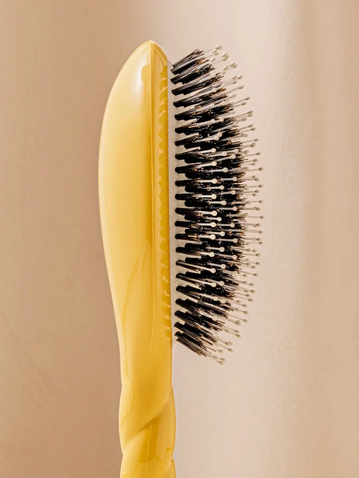 Close-up side image highlights the tiered bristle design of La Bonne Brosse N.03 Large The Essential Softness & Sensitive Scalp Brush in Saffron Yellow | Twentyseven Toronto