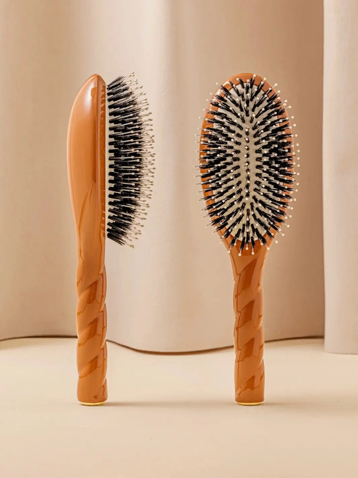 Front and side view of La Bonne Brosse N.03 Large The Essential Softness & Sensitive Scalp Brush in Terracotta featuring a twisted ergonomic handle and natural boar bristles | Twentyseven Toronto
